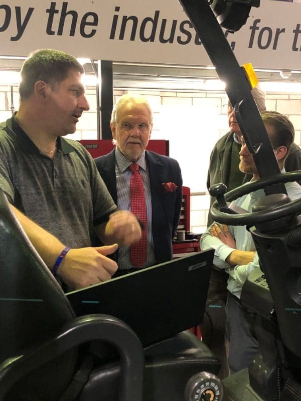 Staff member explaining forklift safety to visitors